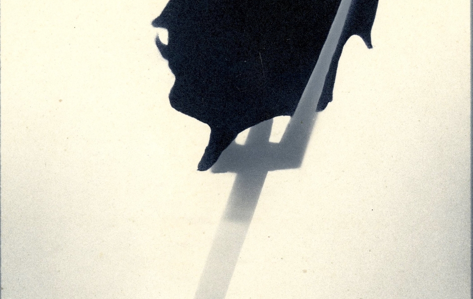 Carte postale ayant pour titre "Une tête de bandit". Elle représente le profil de la tête du Kaiser en ombre chinoise plantée au bout d'une fourche, sortant d'un brouillard.