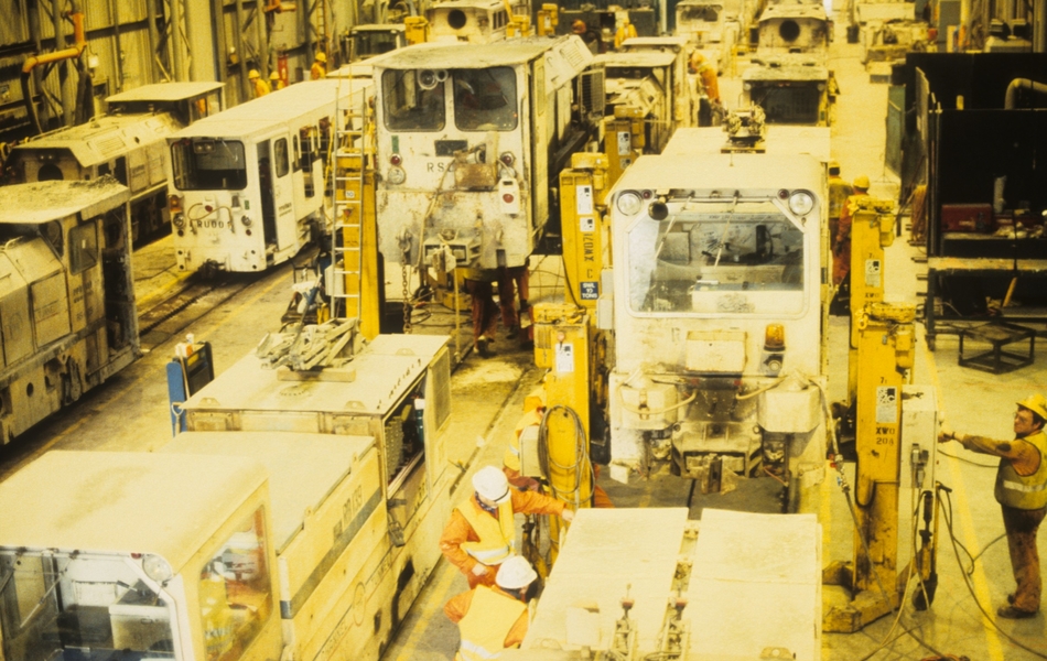 Photographie couleur montrant une salle de machines remplies de wagonnets en cours de construction.