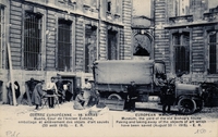 Carte postale noir et blanc montrant des hommes dans la cour du musée en train de charger des cartons dans un camion.