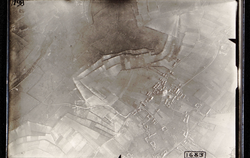 Photographie aérienne noir et blanc montrant des champs traversés de tranchées.