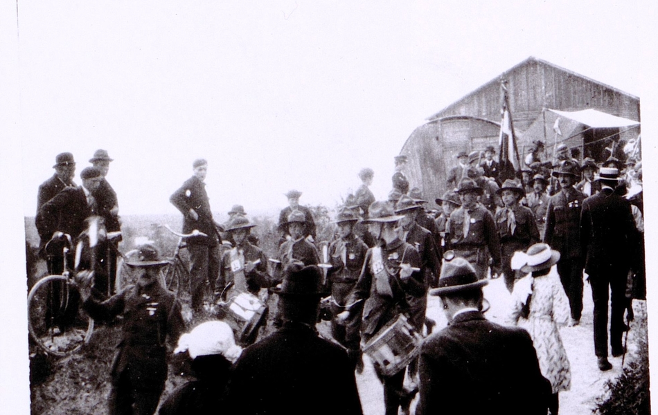 Photographie noir et blanc montrant un défilé de soldats devant une foule.