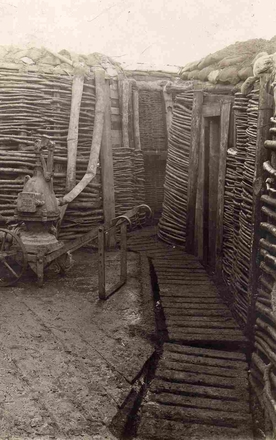 Photographie noir et blanc montrant une tranchée dans laquelle se trouve une pompe.