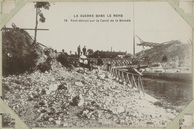Carte postale noir et blanc montrant un pont détruit au-dessus d'une rivière.