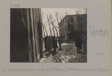 Photographie noir et blanc montrant un groupe d'hommes sur un trottoir.