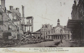 Carte postale noir et blanc montrant une gare aux vitres explosées, entourées de bâtiments détruits.