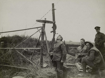 Photographie noir et blanc montrant quatre soldats regroupés autour d'une mitrailleuse dirigée vers le ciel.