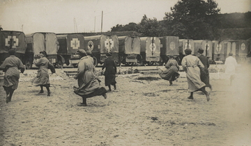 Photographie noir et blanc montrant des femmes courant vers des ambulances.