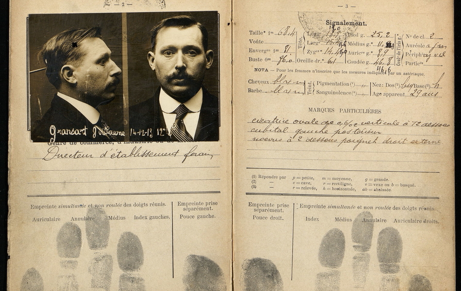 Double page d'un carnet portant une photographie de face et de profil d'un homme, ses empreintes digitales et son signalement physique.