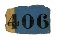 Photographie couleur montrant un morceau de toile peinte en bleu et comportant l'inscription "406" en noir.