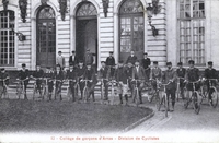 Carte postale noir et blanc montrant des garçons posant sur des vélos.