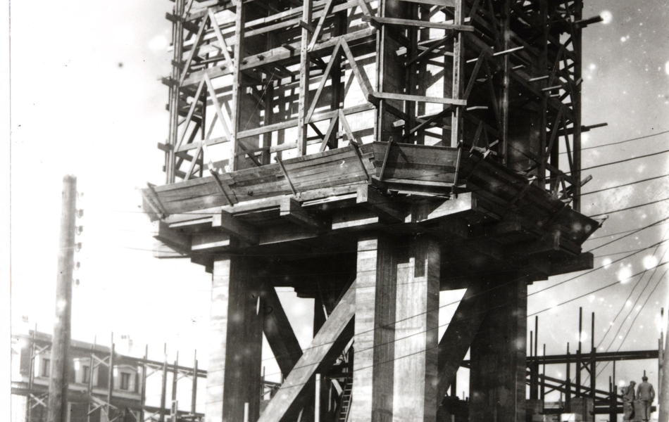 Photographie noir et blanc montrant un chantier d'un bâtiment en construction.