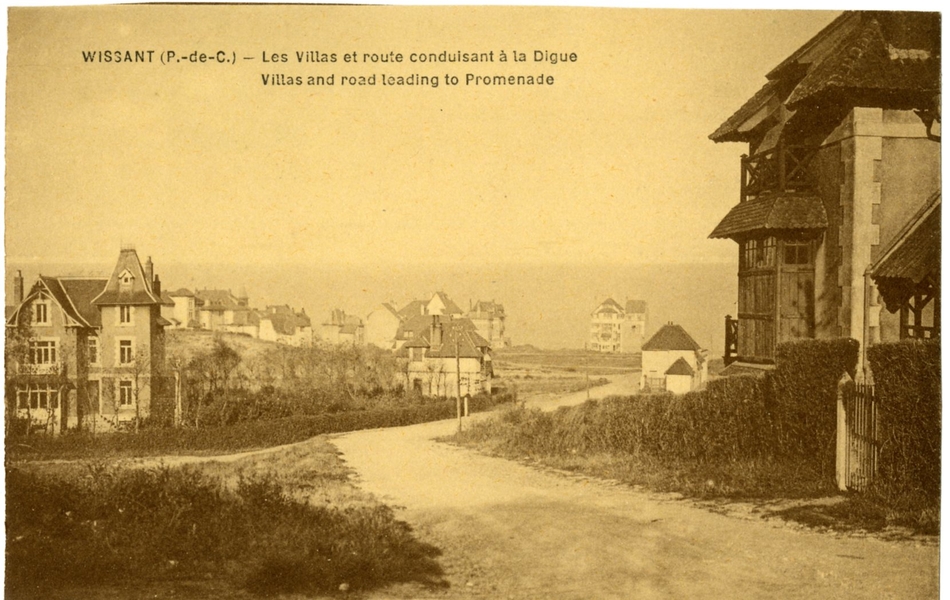 Carte postale en noir et blanc de villas séparées par une route en terre battue menant à la digue