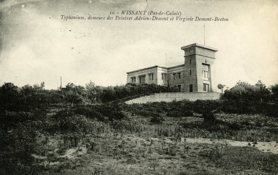 Carte postale en noir et blanc d’une maison de style égyptien perchée sur une dune recouverte de végétation. On y lit : "Typhonium, demeure des peintres Adrien Demont et Virginie Demont-Breton"