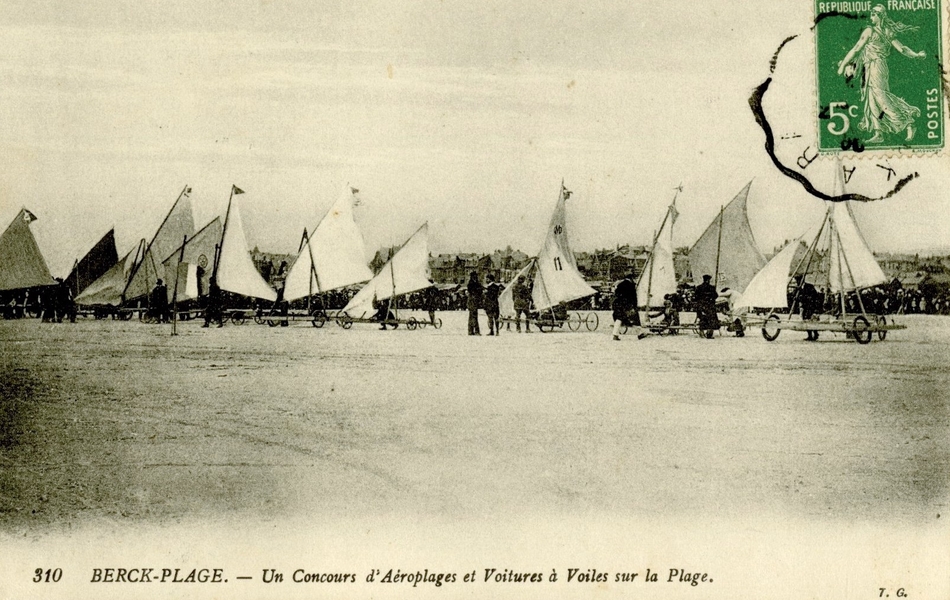 Carte postale noir et blanc montrant des chars à voile sur une plage.