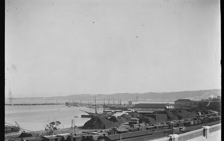 Photographie noir et blanc montrant les docks d'une ville portuaire.