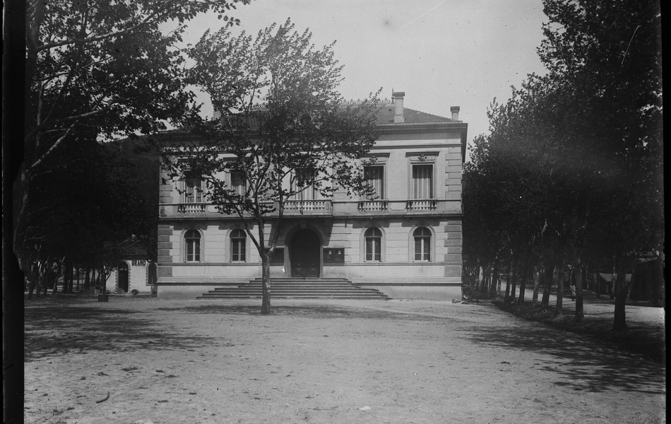 Photographie noir et blanc montrant la façade d'une maison bourgeoise dans un parc.