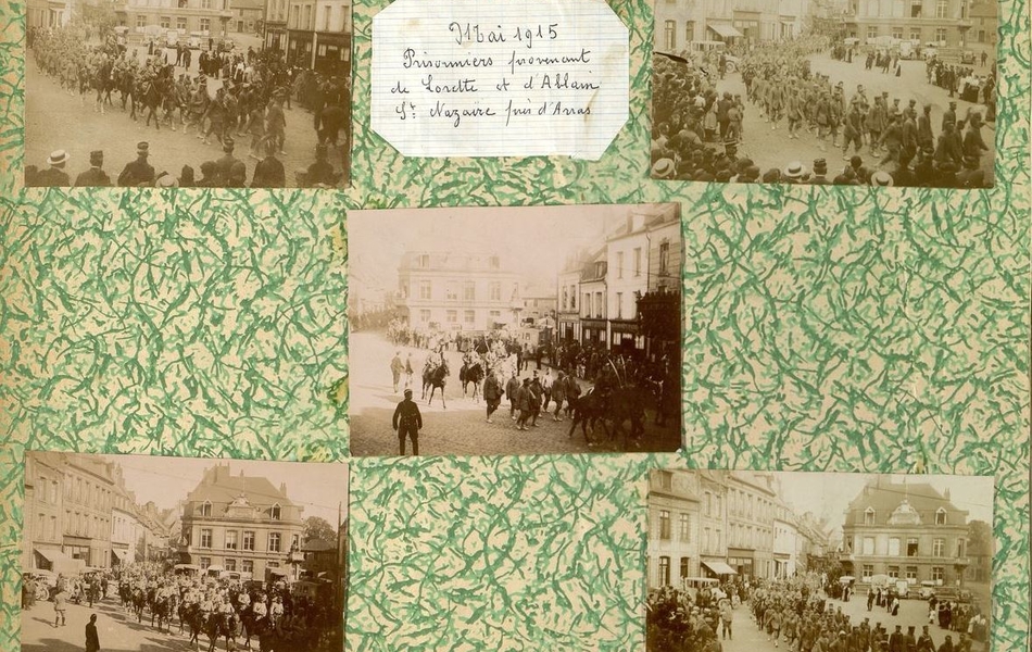 Page d'un album présentant cinq photographies de prisonniers de guerre sur une place.
