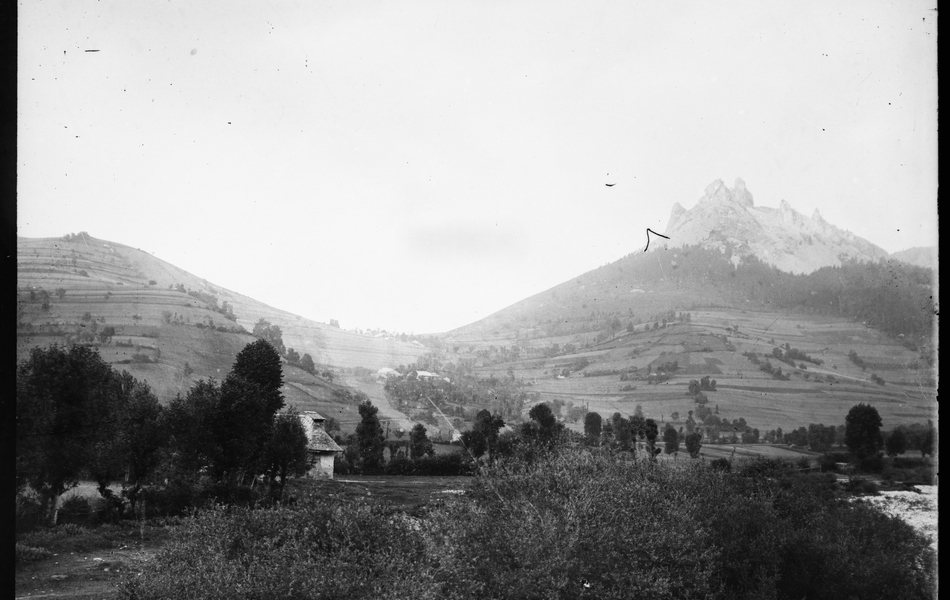 Photographie noir et blanc montrant un paysage vallonné. 