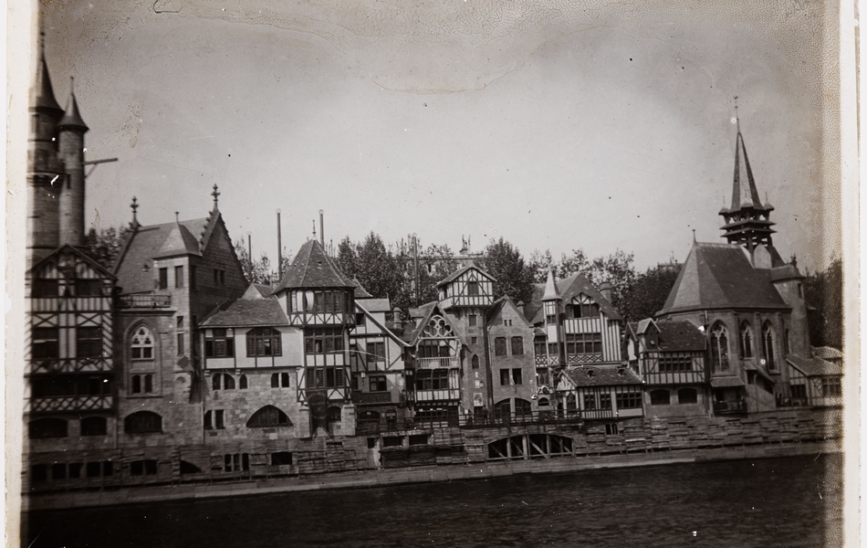Photographie noir et blanc montrant des villas devant un plan d'eau.