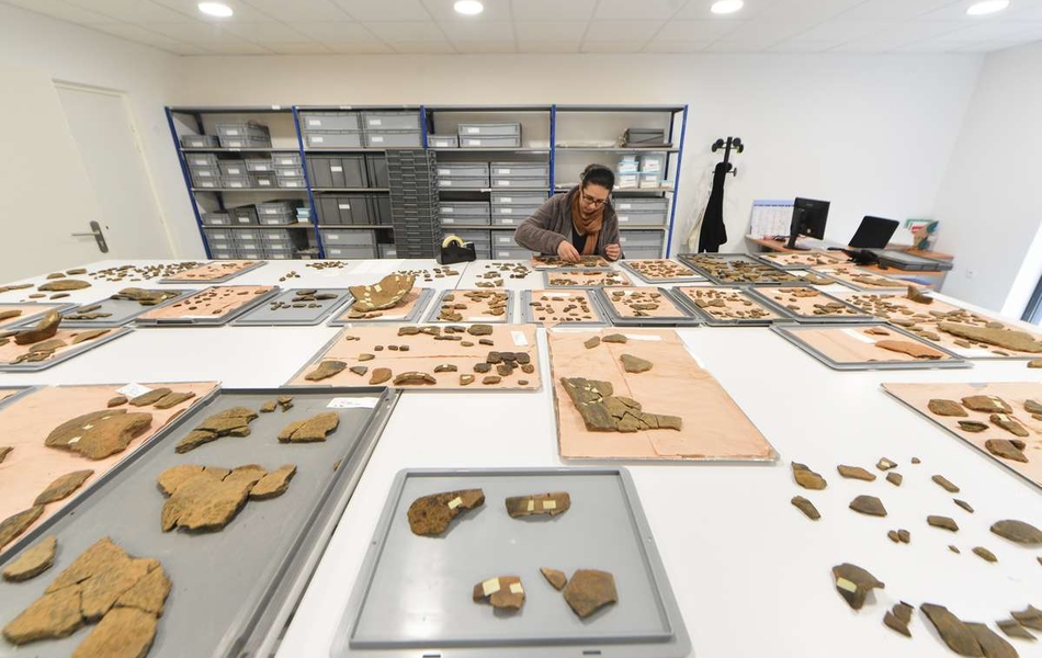 Grande salle d'étude pour observer et analyser les objets archéologiques, ici de la céramique.