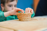 Un enfant réalise un pot.
