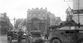 Photographie noir et blanc montrant des chars et des soldats dans des rues.