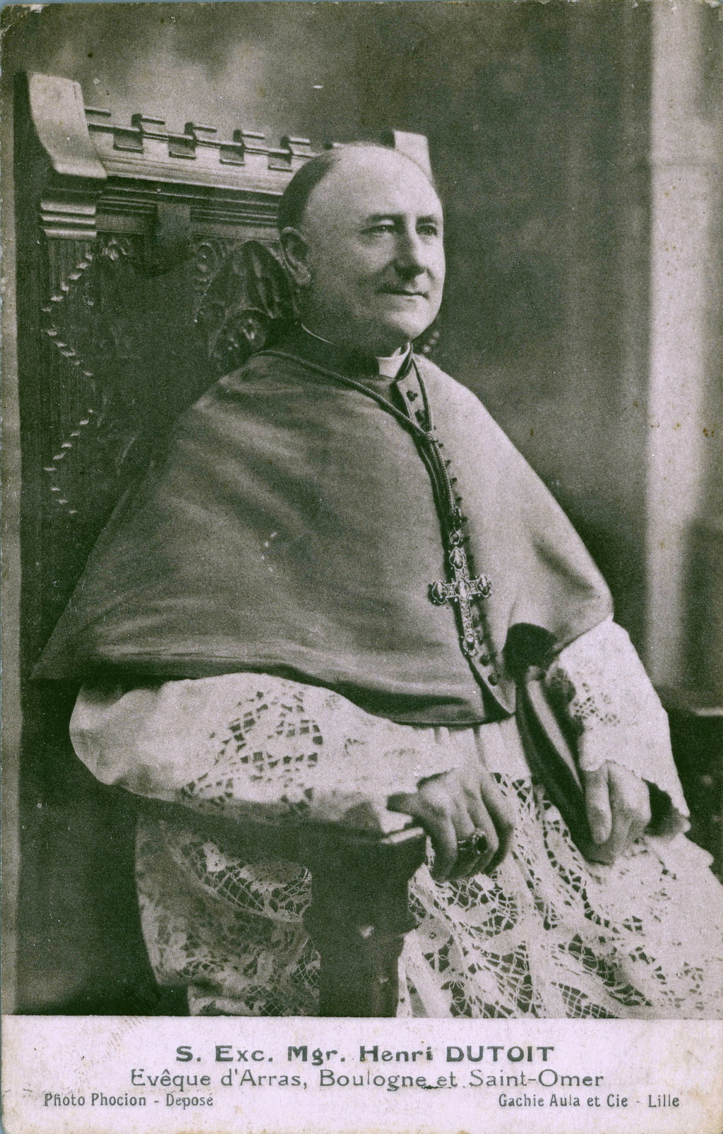 Carte postale noir et blanc montrant un homme vêtu de l'habite épiscopal assis de trois quart.