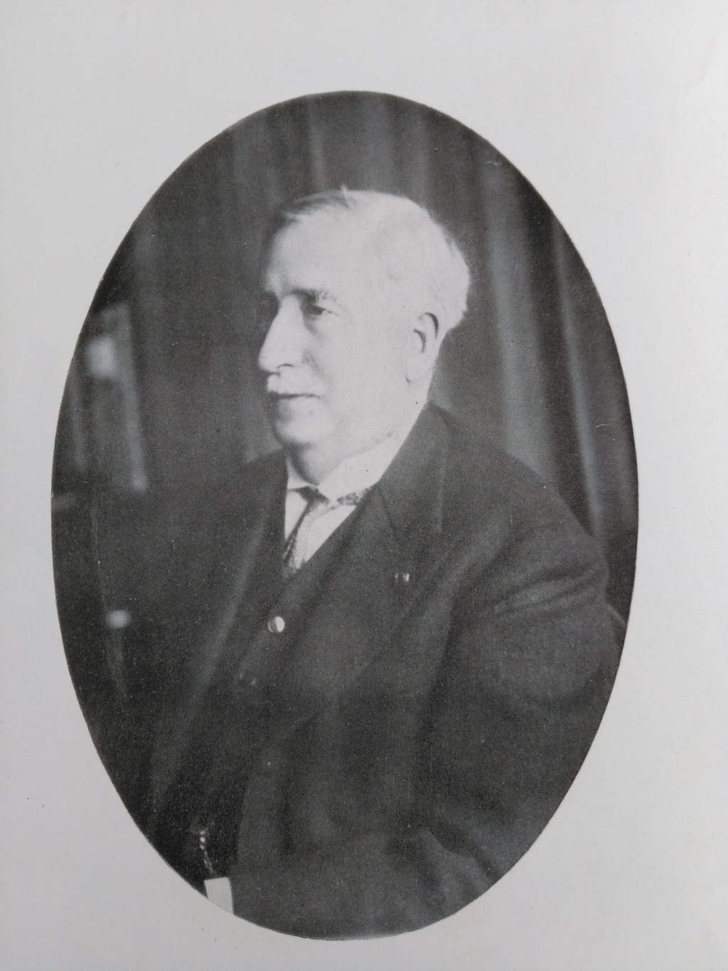 Photographie noir et blanc en médaillon d'un homme âgé tourné de trois-quart.