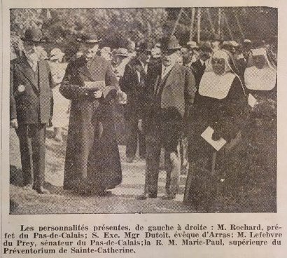 Photographie d'un journal noir et blanc, sur laquelle est représenté un groupe de personnes (trois hommes et deux religieuses). En-dessous, la légende suivante : "Les personnalités présentes, de gauche à droite : M. Rochard, préfet du Pas-de-Calais ; son Excellence Monseigneur Dutoit, évêque d'Arras ; M. Lefebvre du Prey, sénateur du Pas-de-Calais ; la R. M. Marie-Paul, supérieure du préventorium de Sainte-Catherine".