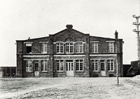 Photographie noir et blanc de la façade d'un bâtiment.