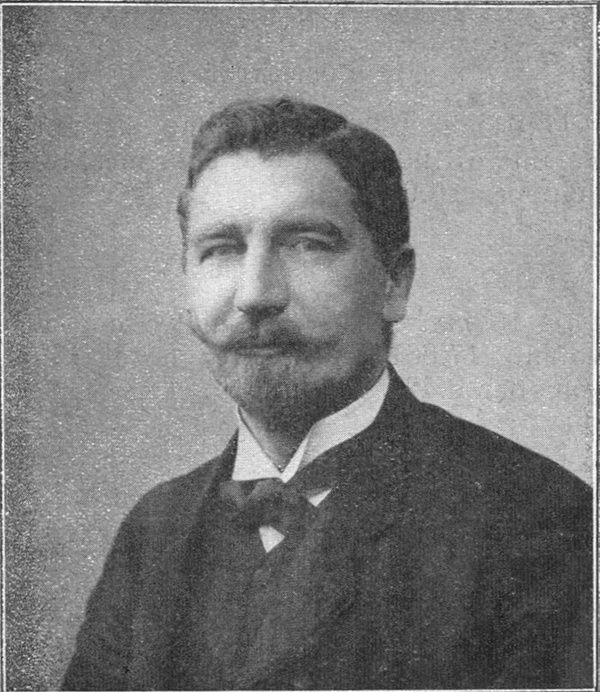 Portrait noir et blanc d'un homme moustachu.