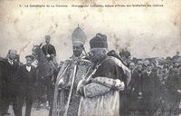 Carte postale noir et blanc montrant deux ecclésiastiques précédant une foule.