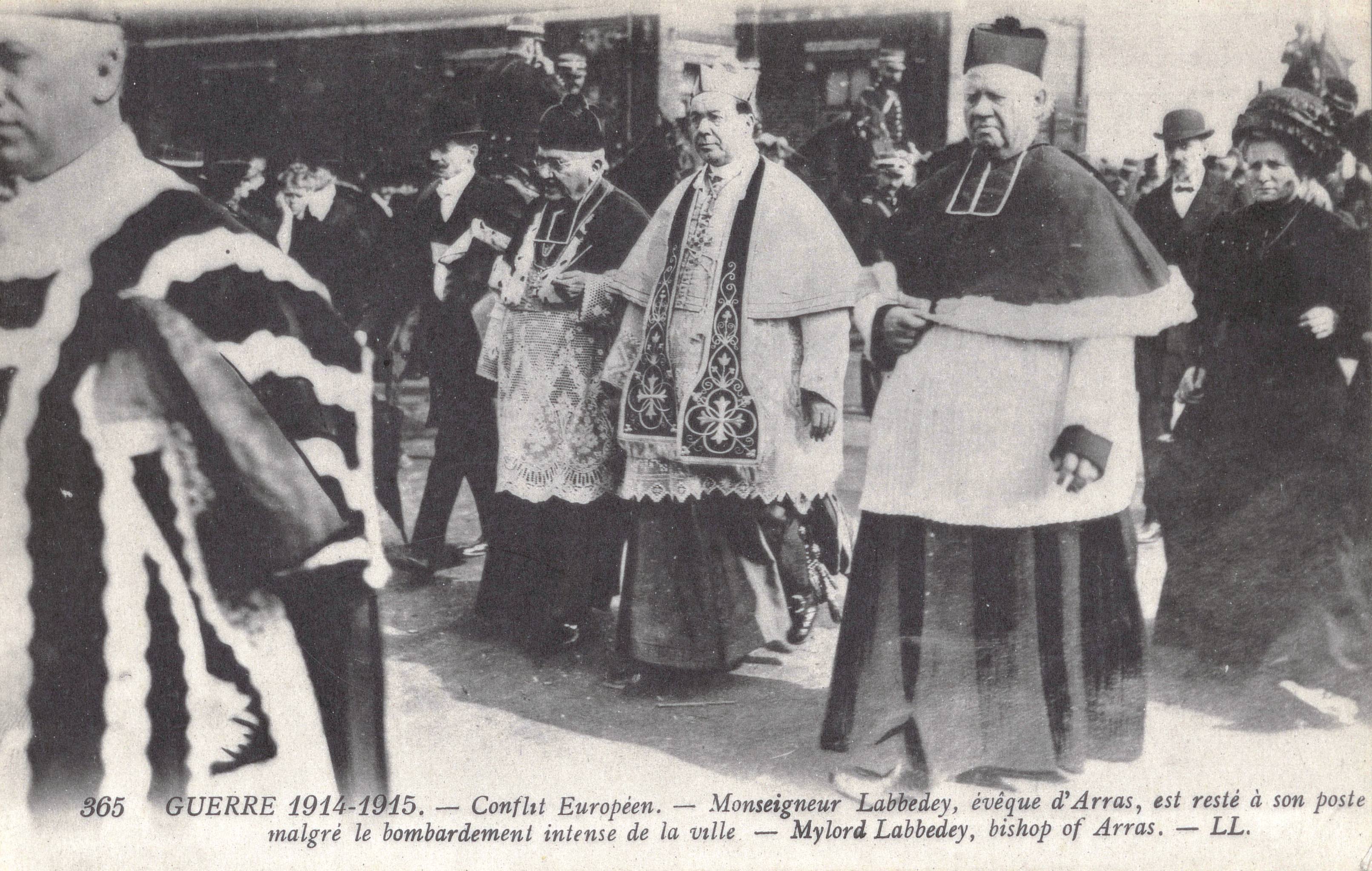 Carte postale noir et blanc montrant un groupe de prélats en train de marcher, entourés d'une foule de civils.