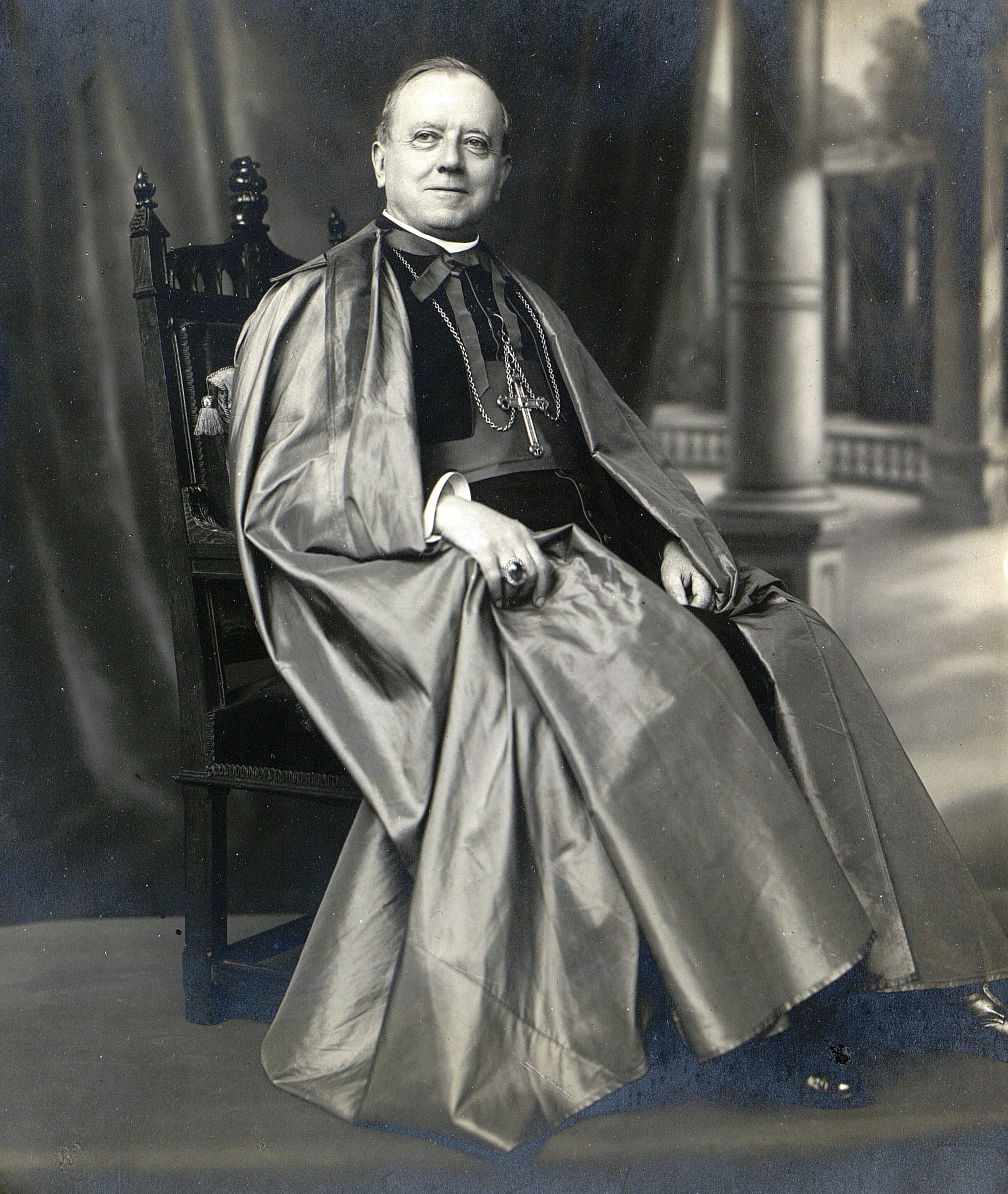Photographie noir et blanc d'un homme d'église assis.