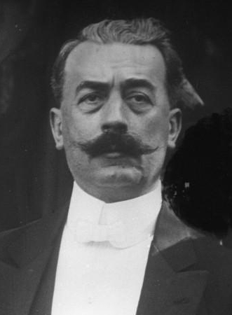Portrait noir et blanc d'un homme moustachu.