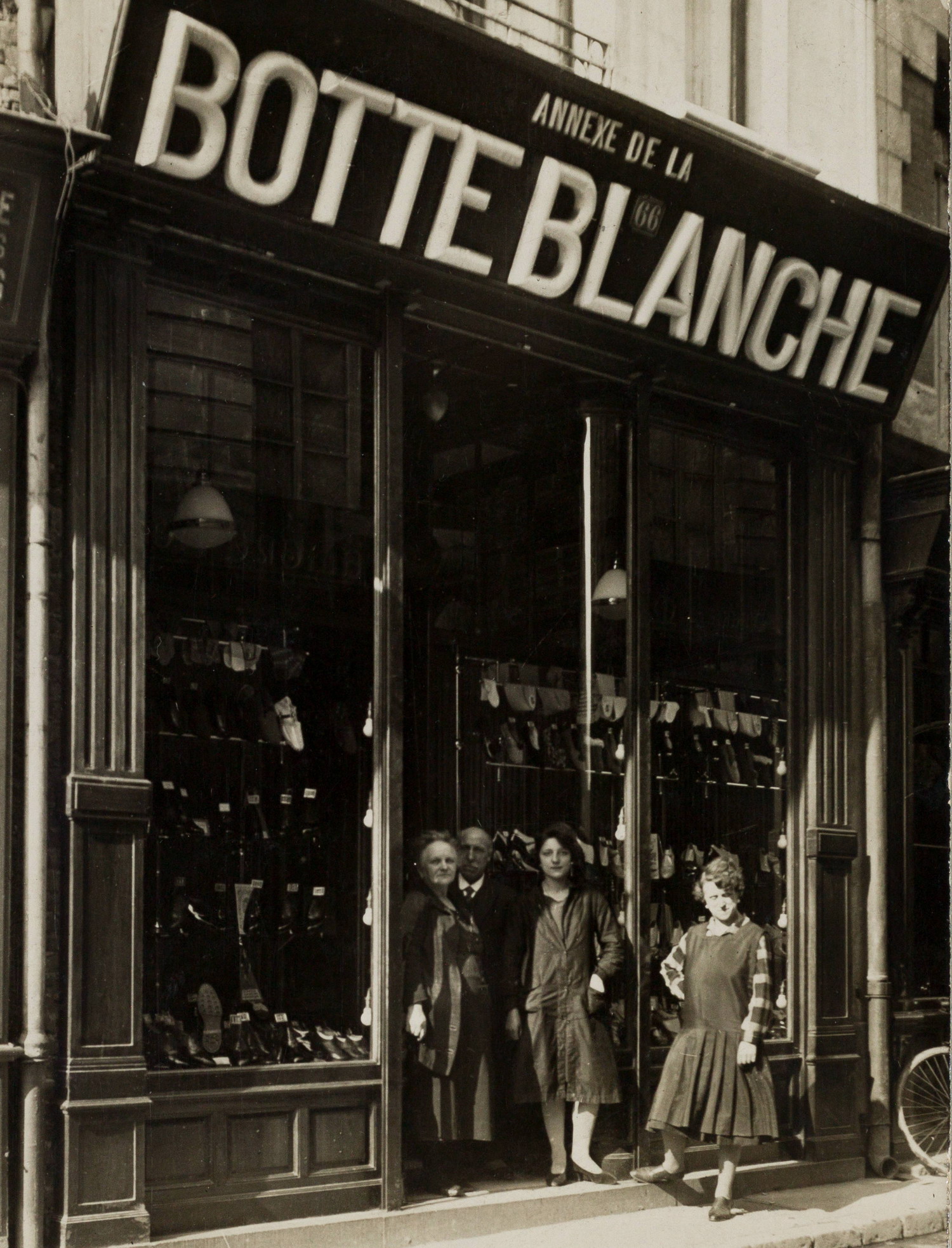Photographie noir et blanc montrant quelques femmes devant une devanture sur laquelle on lit :"Annexe de la botte blanche".