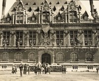 Photographie noir et blanc montrant la façade d'un grand bâtiment portant une grande décoration militaire.