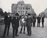 Photographie noir et blanc montrant un groupe d'hommes sur une place.
