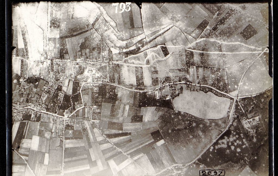 Photographie aérienne noir et blanc montrant des champs traversés de tranchées.