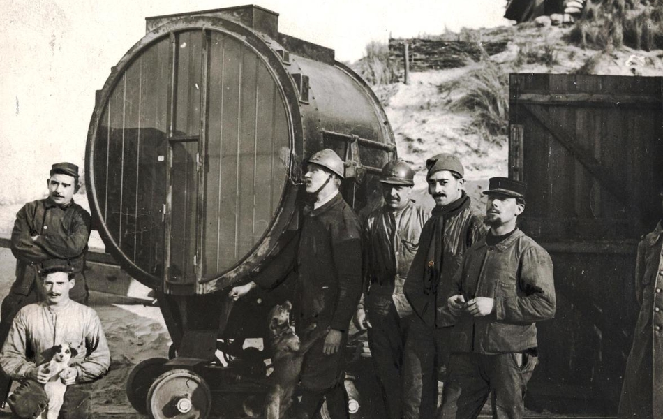 Groupe d'hommes aux côtés d'un grand projecteur sur une plage.