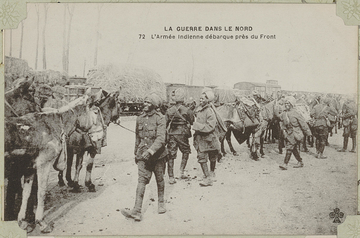 Carte postale noir et blanc montrant des soldats indiens souriant décharger des baages de leurs montures.