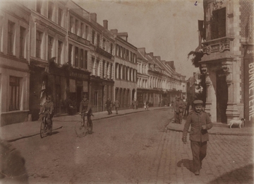 Photographie sepia montrant une rue dans laquelle passent des soldats allemands.