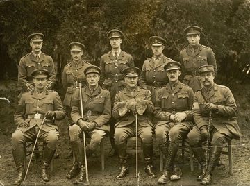 Photographie noir et blanc montrant un groupe de militaires posant sur deux rangs devant un photographe.