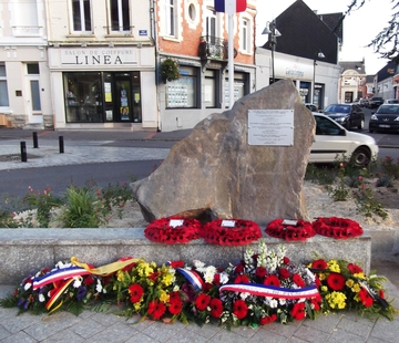 Photographie couleur représentant une pierre commémorative sur laquelle est apposée un plaque.