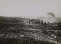 Photographie noir et blanc montrant des soldats sur un champ de bataille enfumé.