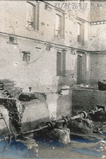 photographie noir et blanc montrant des tuyaux sortant du sous-sol d'un bâtiment détruit.