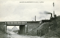 Carte postale noir et blanc montrant un train à l'arrêt en haut d'un pont.
