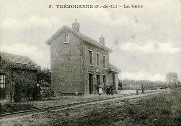 Carte postale noir et blanc montrant une voie ferrée devant un petit bâtiment.