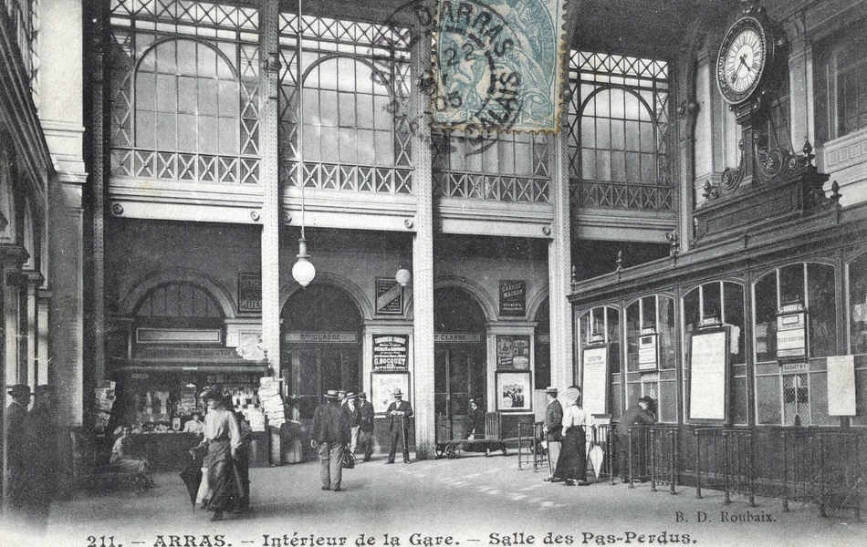 Carte postale noir et blanc montrant l'intérieur d'un hall de gare.