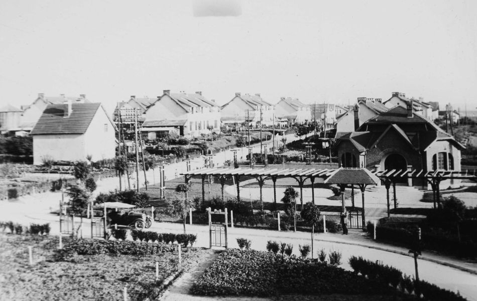 Photographie noir et blanc montrant des jardins autour de maisons.